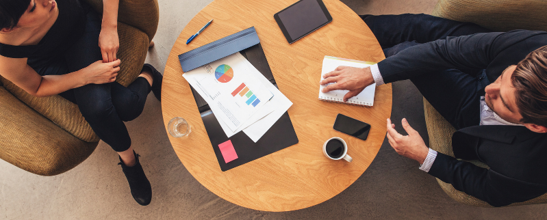 Homme et femme discutant autour de graphiques